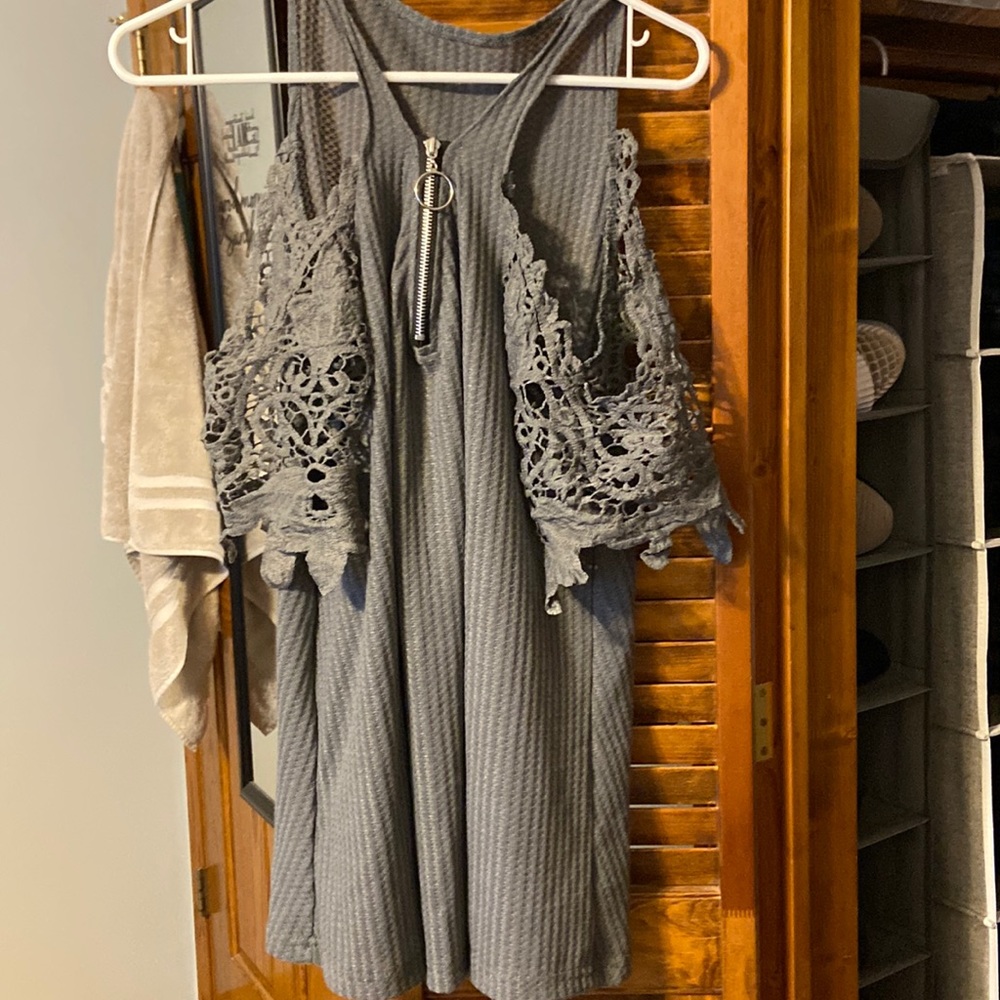 Grey tunic with exposed shoulder design. The sleeves have a knit like design.